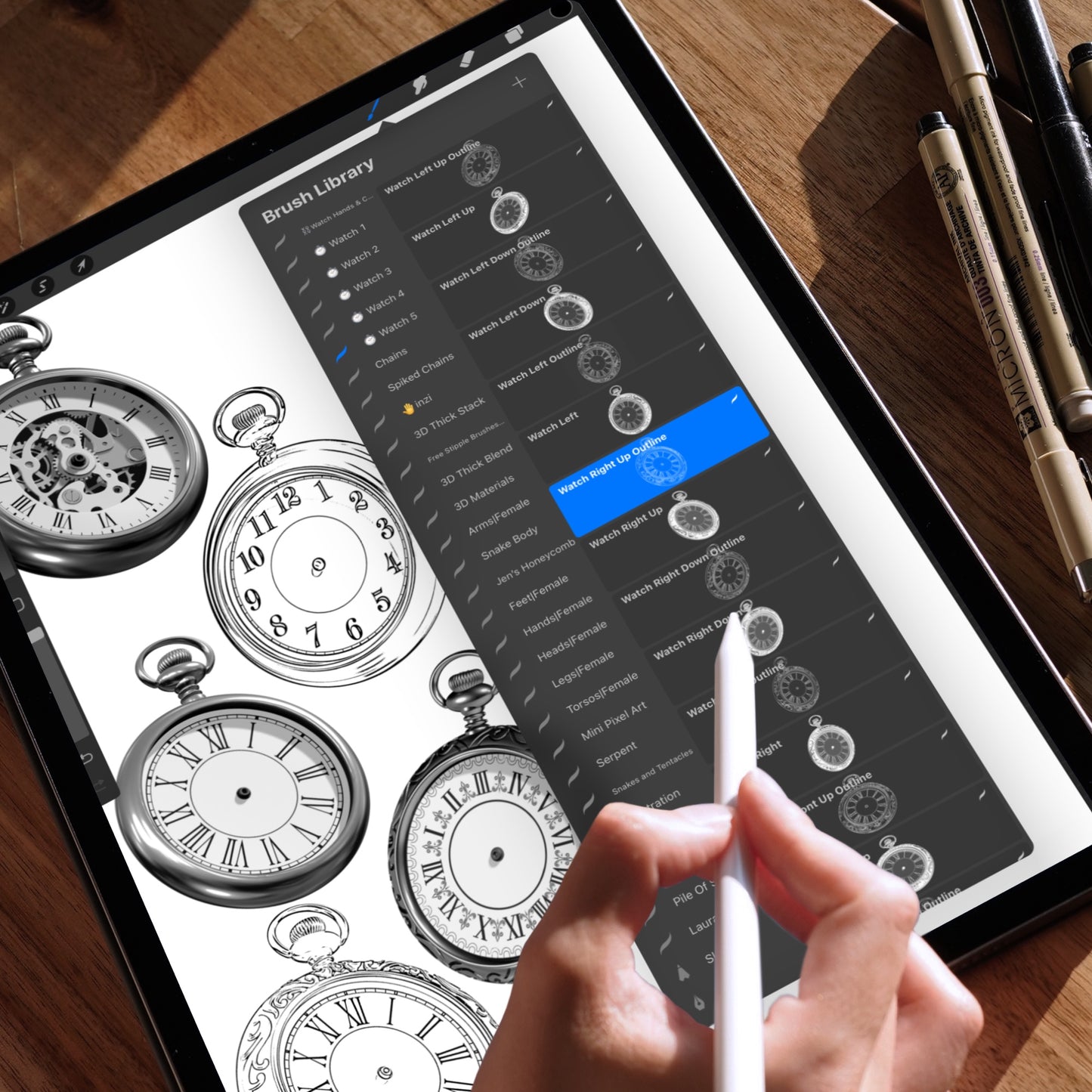 iPad screen showing Procreate with a detailed pocket watch and chain being drawn. A hand holds an Apple Pencil while selecting a custom brush from the brush library.