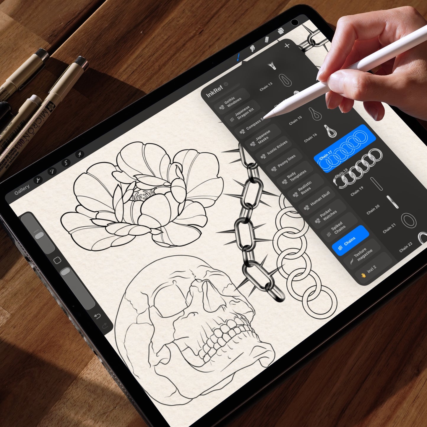 InkRef chain brushes in Procreate on iPad — tattoo artist inking a peony, skull and spiked chain with Apple Pencil